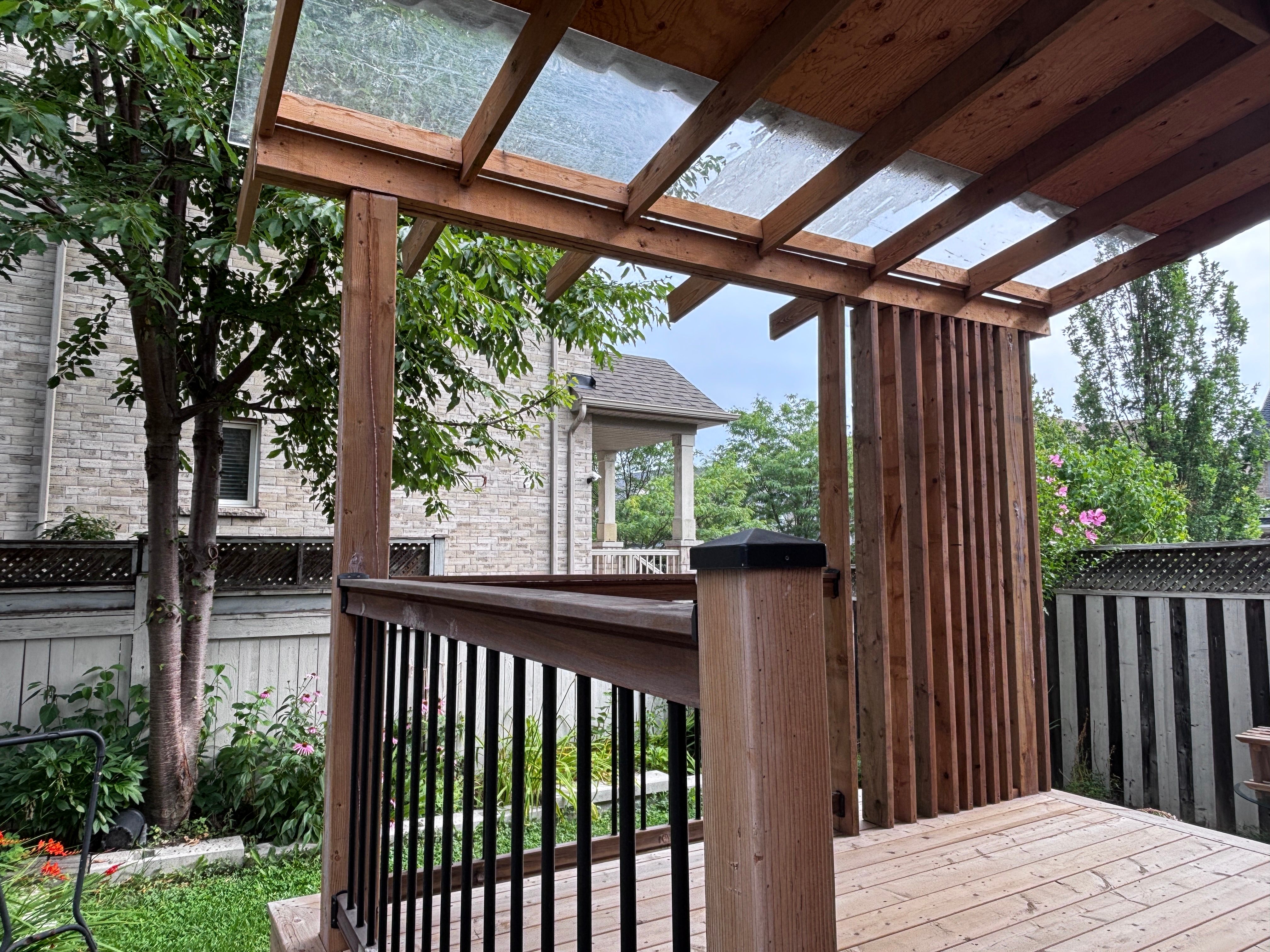 Deck before the protective paint project, viewed from beneath the pergola
